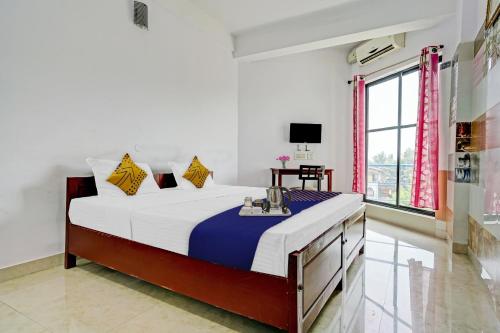 a bedroom with a large bed and a window at SPOT ON Cherai Homes in Cherai Beach
