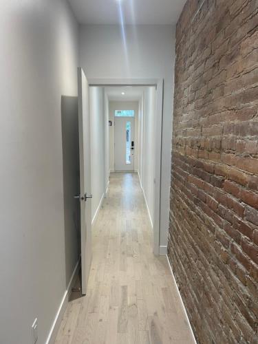 a hallway with a brick wall and a hallway with a door at Hochelag Nook in Montreal