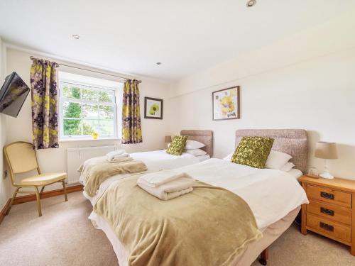 ein Schlafzimmer mit zwei Betten und einem Fenster in der Unterkunft Old Rectory Cottages in Aberhafesp