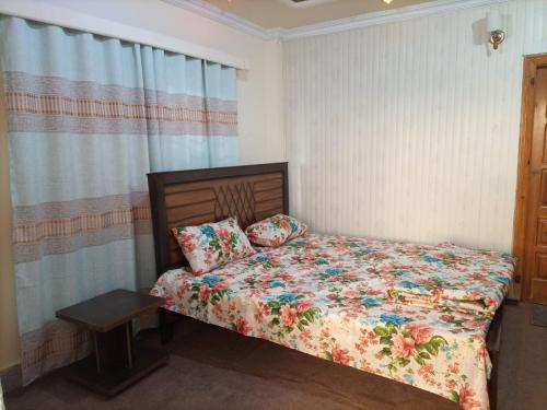 a bedroom with a bed with a floral comforter at Galaxy apartments in Lower Topa