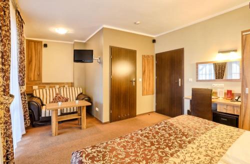 a hotel room with a bed and a couch at Hotel Dębowe Wzgórze Wellness & Spa in Jarnołtówek
