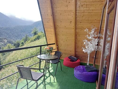 a table and chairs on a balcony with a view at Eco cottage sunrise merisi in Merisi