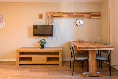 uma sala de jantar com uma mesa e um relógio na parede em Résidence L'Atelier em Ennezat