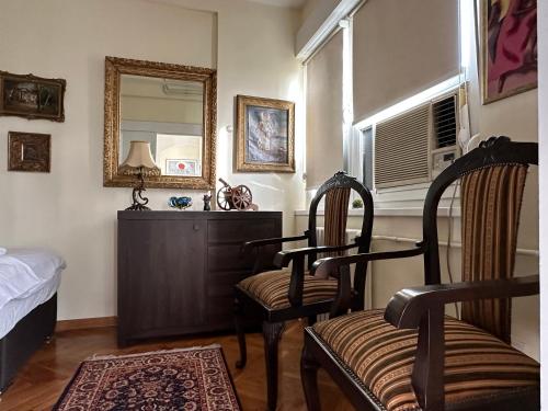 1 dormitorio con 2 sillas, tocador y espejo en Vintage Delight Apartment Vracar Hram Sv Save, en Belgrado