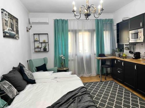 ein Schlafzimmer mit einem Bett und eine Küche mit einem Schreibtisch in der Unterkunft Studio Villa Floreasca in Bukarest