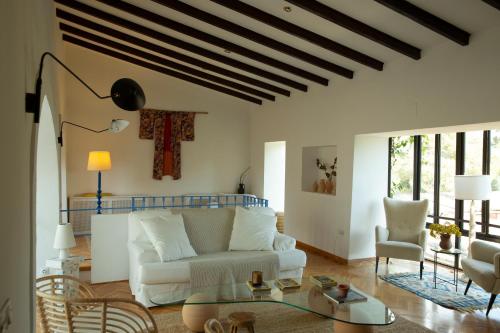 a living room with a white couch and chairs at Casa Balandra: Experiential Guesthouse in Pòrtol