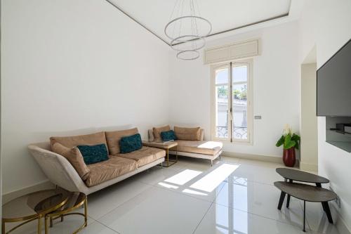 ein Wohnzimmer mit einem Sofa und einem Tisch in der Unterkunft Superb 68m2 flat with 80m2 terrace - 2Ch4p in Cannes