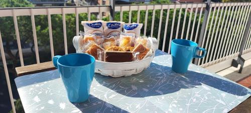 a table with a bowl of food and two blue cups at La Casetta Di Nonna Anna - 120 mq Bright Apartment in Rome in Rome