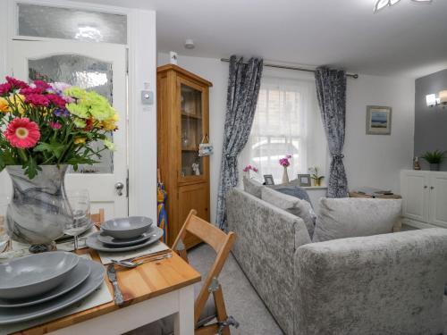 a living room with two couches and a table with flowers at The Bay Cottage - Morecambe Bay in Morecambe
