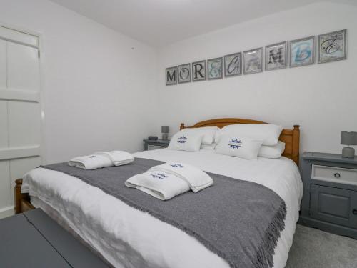 a bedroom with a large bed with pillows on it at The Bay Cottage in Morecambe