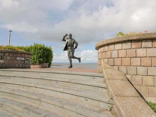 a statue of a man is standing on the stairs at The Bay Cottage - Morecambe Bay in Morecambe