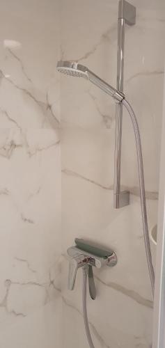 a shower seat in a bathroom with marble walls at Concord Luxury Apartment in Warsaw