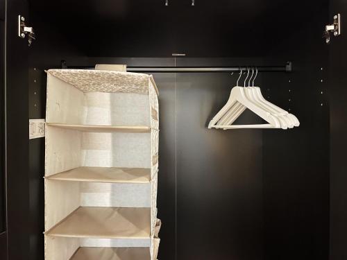 a closet with white shelves and a black wall at Cozy city center apartment in Visaginas