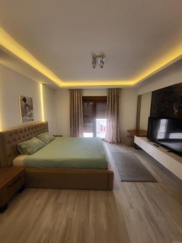 a bedroom with a bed and a flat screen tv at JOANDI Apartments in Gevgelija