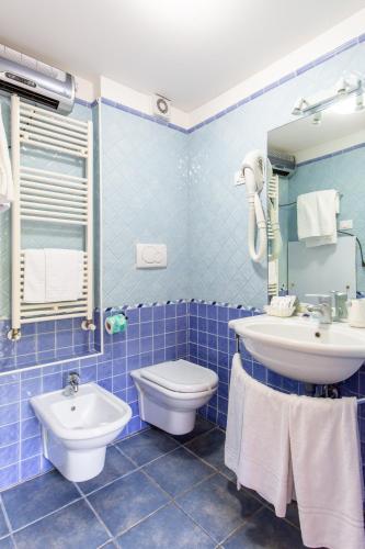 a blue tiled bathroom with a sink and a toilet at Hotel Sant'Andrea in Ravenna