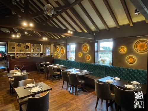 um restaurante com mesas e cadeiras num quarto em The Boutique Hotel em Faringdon