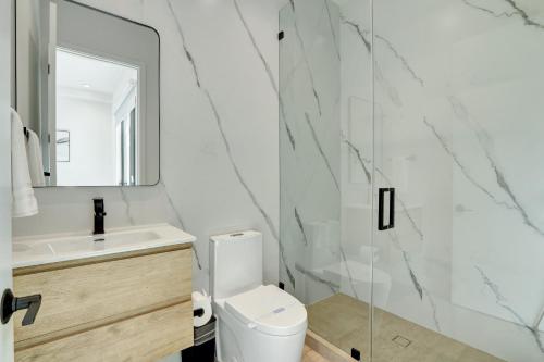 a bathroom with a toilet and a sink and a mirror at Fresco 1, Modern Design, Brand New Construction and Furniture in Miami