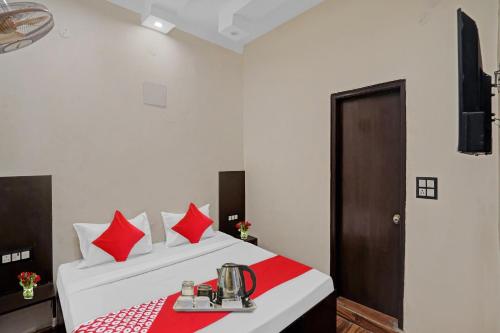 a hotel room with a bed with red pillows at OYO Flagship Kwins Residency in Ghaziabad