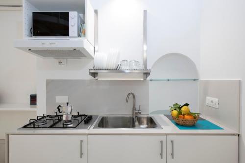a white kitchen with a sink and a microwave at Strit strit centro storico in Amalfi
