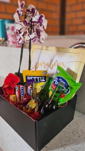 a gift box with snacks and a flower at Pousada Doce Mar in Guarda do Embaú