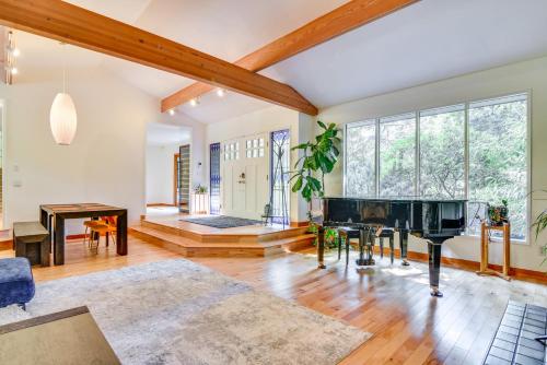 een woonkamer met een piano en een tafel bij Contemporary Portland Retreat with Forest Views in Portland