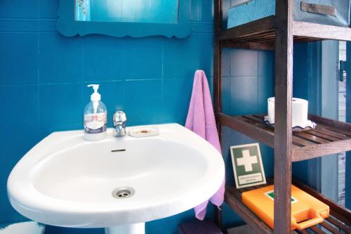 a bathroom with a white sink and a blue wall at Love Temple in Ericeira