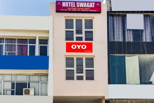 Ein weißes Gebäude mit einem Schild drauf. in der Unterkunft OYO Hotel Swagat in Zirakpur