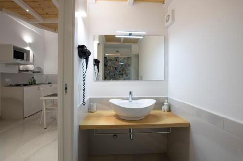bagno con lavandino bianco e specchio di Strit strit centro storico ad Amalfi
