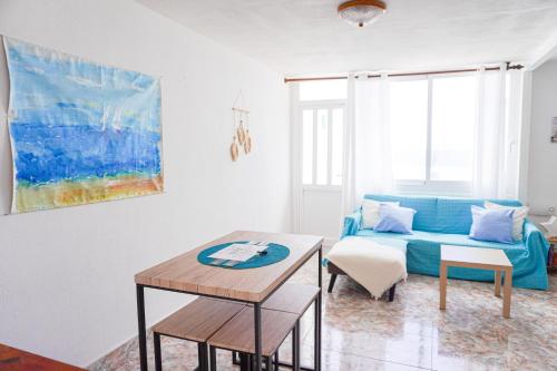 a living room with a blue couch and a table at Marina Blue, Las Caletillas in Candelaria