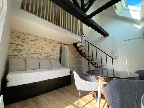 une chambre avec un lit, une table et des chaises dans l'établissement La Douce Angevine - Le Perroquet, à Angers