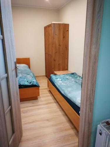 twee bedden in een kamer met een deur open bij Kwatery pracownicze in Środa Wielkopolska