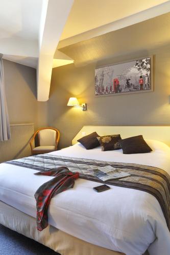 a hotel room with two beds in a room at Hôtel Les Tilleuls, Bourges in Bourges