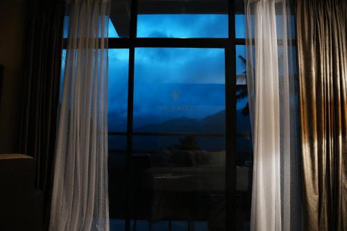 a window with a view of a mountain view at Viceroy Luxury Mountain Resort and Spa in Munnar