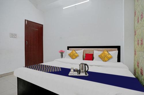 a bedroom with a large bed with blue and yellow pillows at SPOT ON Hotel Srb in Jodhpur