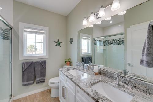 a bathroom with a sink and a toilet and a mirror at Bright, Modern Corpus Christi Condo 2 Mi to Beach in Padre Island