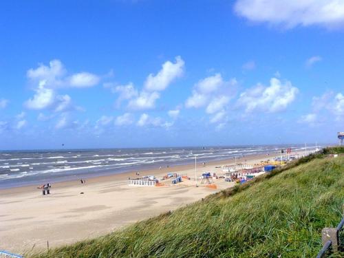 una playa con gente en la arena y el océano en Zuidwest Zeven free parking! en Zandvoort