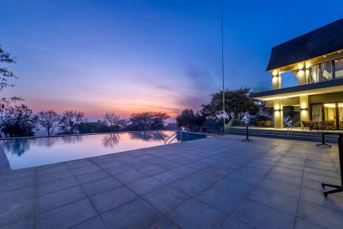 a view of a house with a swimming pool at dusk at La Joya Lodge Conference Centre and Spa in Pelindaba