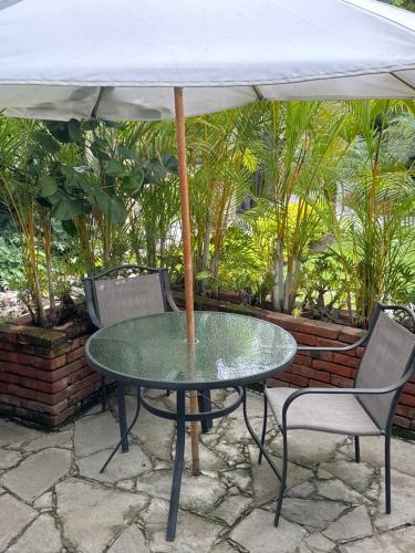 a table and chairs with an umbrella on a patio at Casa Miura Hotel Boutique in Ajijic