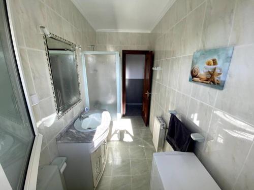 a white bathroom with a sink and a toilet at Villa Senda costera. Un lugar natural en la ciudad in Santander