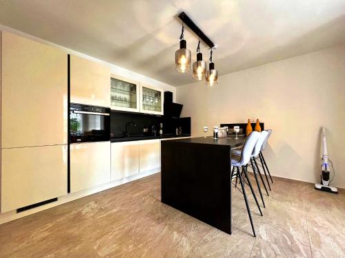 a kitchen with a black island in a room at Villa Olivija-direkt am Strand! in Stara Novalja