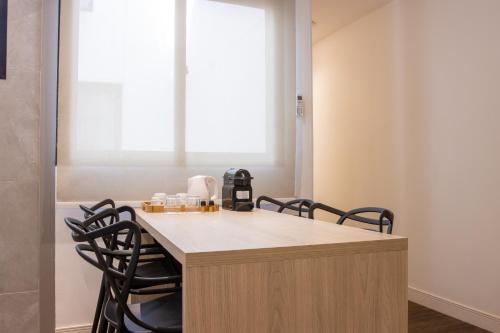 eine Küche mit einer Theke mit Stühlen drum herum in der Unterkunft AnnA Suites Ipanema in Rio de Janeiro