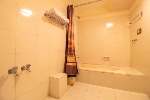 a bathroom with a tub and a shower and a sink at Hotel Negi's Mayflower A heritage Since 1965 in Manāli