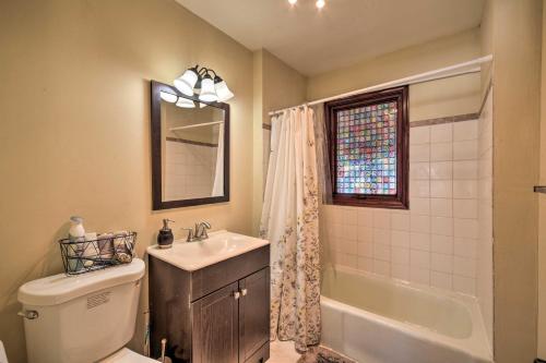 a bathroom with a toilet and a sink and a mirror at Danbury Cabin with Wraparound Porch on Lang Lake! in Danbury