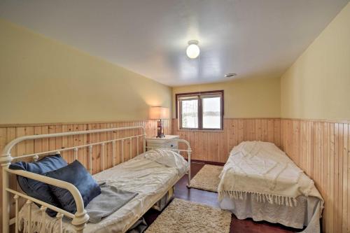 a bedroom with two beds and a window at Danbury Cabin with Wraparound Porch on Lang Lake! in Danbury
