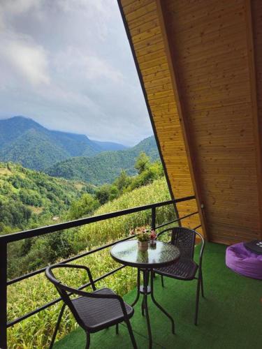 a table and chairs on a balcony with a view at Eco cottage sunrise merisi in Merisi