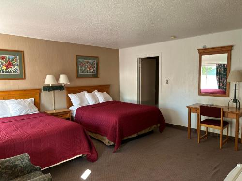 a hotel room with two beds and a desk at Redwood Arms Motel in Paonia