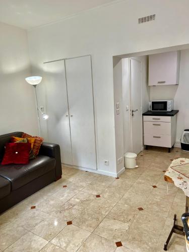 un salon avec un canapé et une cuisine dans l'établissement Studio butte aux cailles, à Paris