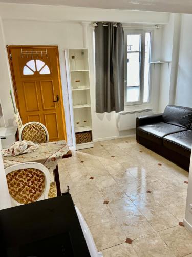 - un salon avec un canapé, une table et une porte dans l'établissement Studio butte aux cailles, à Paris