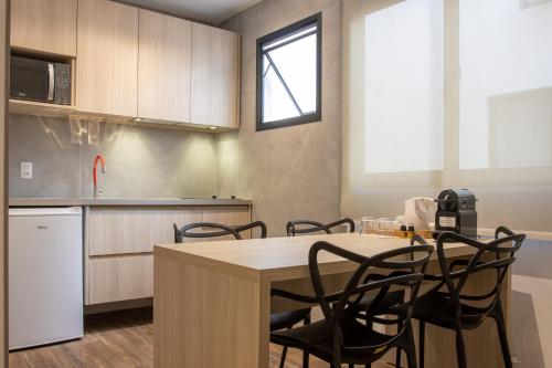eine Küche mit einem Tisch und Stühlen im Zimmer in der Unterkunft AnnA Suites Ipanema in Rio de Janeiro