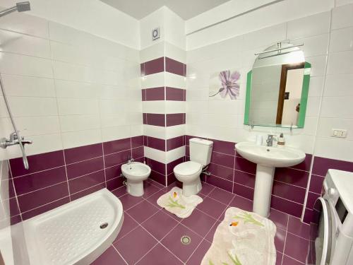 y baño con lavabo, aseo y espejo. en Durres Apartament, en Durrës